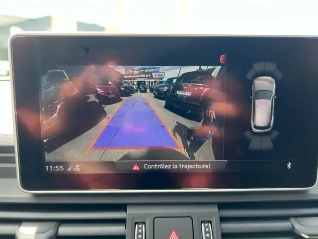 Écran de caméra de recul de l'Audi Q5 gris foncé 2018, affichant la trajectoire et les véhicules derrière.