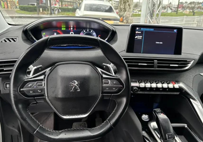 Vue intérieure centrée sur le volant compact et le tableau de bord numérique du Peugeot 3008 blanc de 2018.