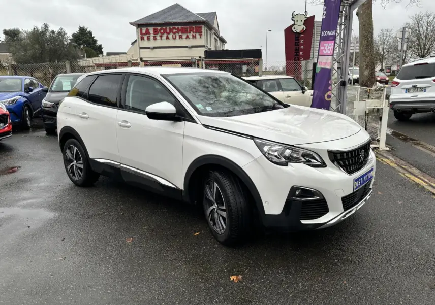 Peugeot 3008 blanc nacré en 3/4 avant droit sur parking, avec jantes alliage et calandre noire distinctive.