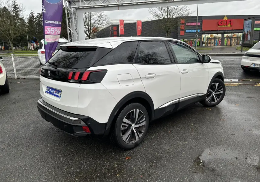 Vue 3/4 arrière droite d'un Peugeot 3008 blanc nacré avec vitres surteintées et jantes alliage 18 pouces.