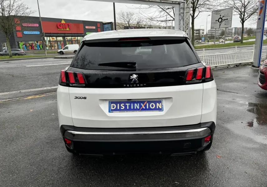 Vue arrière d'un Peugeot 3008 blanc nacré avec feux arrière à trois griffes et lunette arrière surteintée.