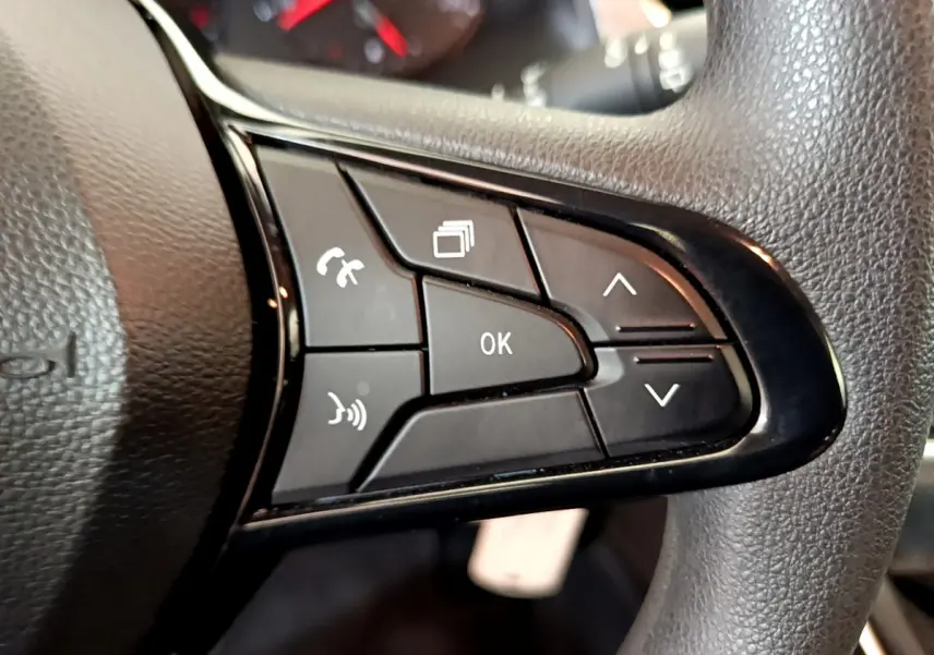 Gros plan sur les commandes multifonctions noires du volant du Renault Kangoo bleu 2023, version Equilibre TCe 100.