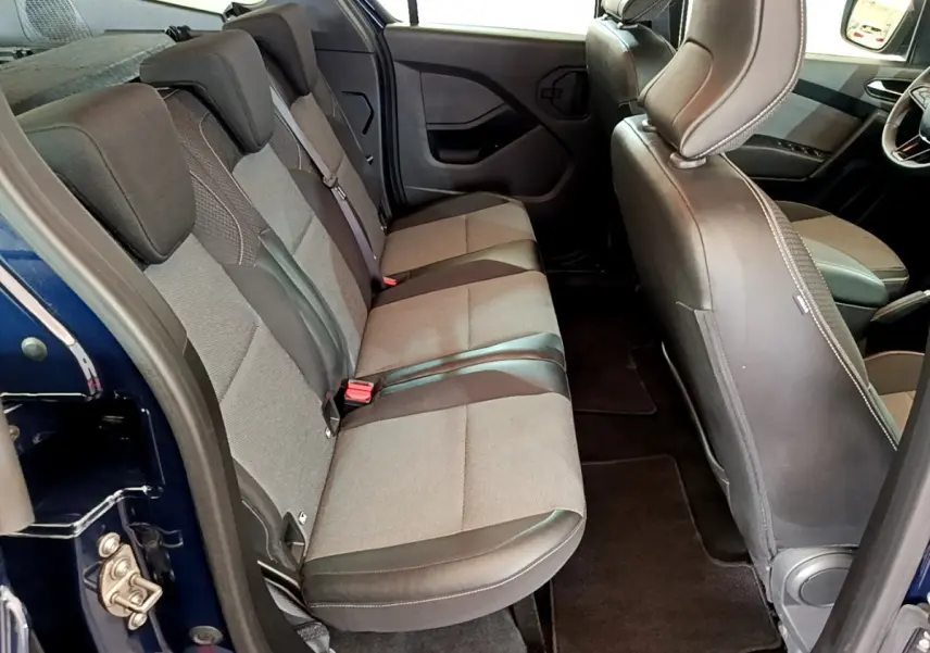 Vue intérieure côté gauche sur la banquette arrière grise et noire du Renault Kangoo Bleu 2023, avec sièges rabattables.