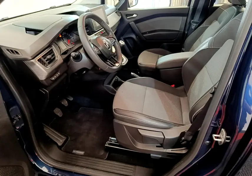 Intérieur avant droit du Renault Kangoo bleu 2023, sièges gris, volant multifonctions et tableau de bord moderne.