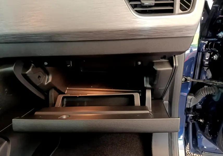 Intérieur du Renault Kangoo Equilibre 2023 bleu, vue sur la boîte à gants ouverte côté passager.