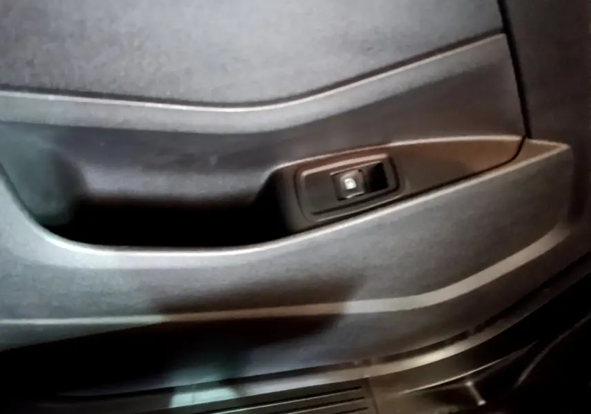 Gros plan sur la poignée intérieure de porte noire du Renault Kangoo Equilibre TCe 100 2023, finition sobre.