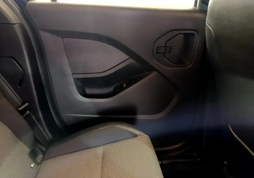 Vue intérieure côté droit arrière du Renault Kangoo 2023, montrant la portière noire et la banquette grise.