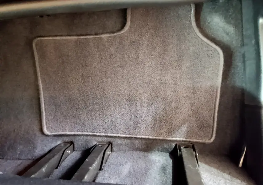 Gros plan sur le plancher arrière gris du Renault Kangoo bleu 2023, montrant les rails de fixation des sièges.