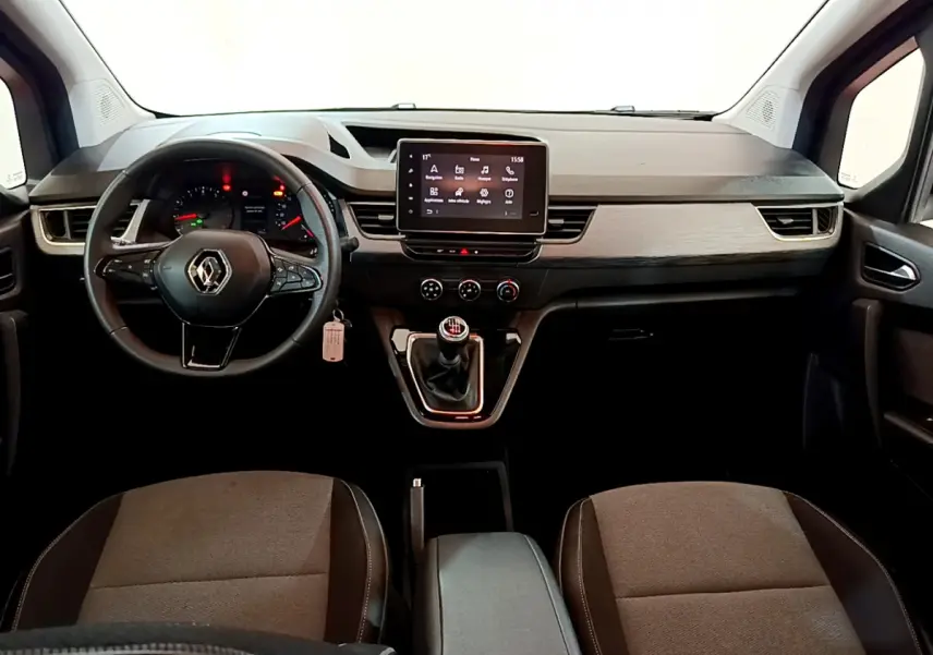 Vue intérieure avant du Renault Kangoo 2023, tableau de bord moderne avec écran tactile central et volant multifonctions.