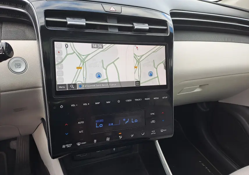 Vue rapprochée du tableau de bord beige du Hyundai Tucson 2023 avec écran tactile et commandes climatisation digitales.