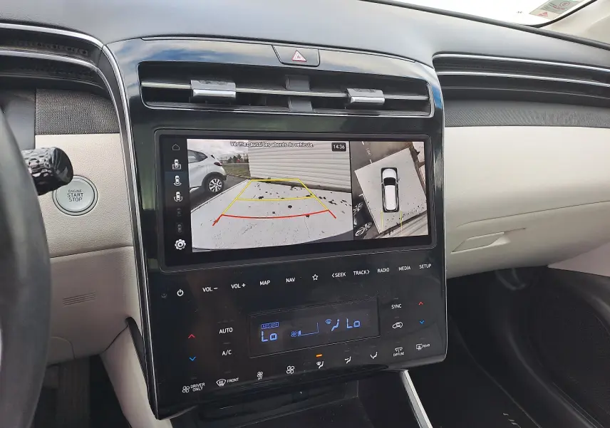 Vue rapprochée de la console centrale beige du Hyundai Tucson 2023 avec écran tactile affichant la caméra de recul.