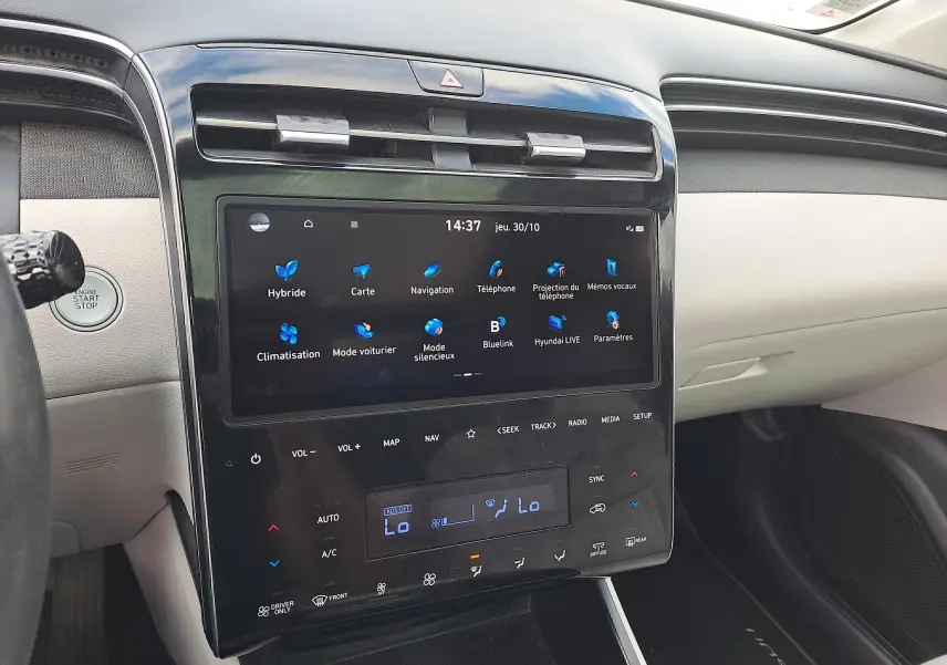 Vue rapprochée de la console centrale du Hyundai Tucson 2023, écran tactile et finition beige intérieure visible.