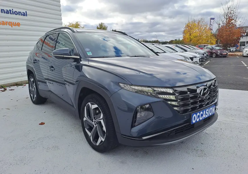 Hyundai Tucson Cypress Green 2023 en 3/4 avant droit, avec calandre imposante et jantes modernes sur parking.