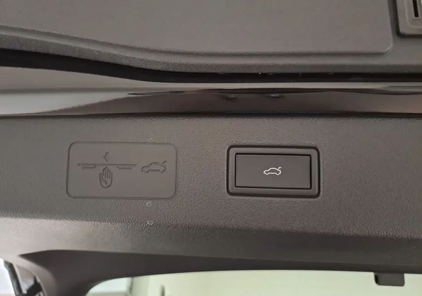 Détail du bouton d'ouverture électrique du coffre sur le hayon intérieur du Volkswagen T-Roc noir ébène 2026.