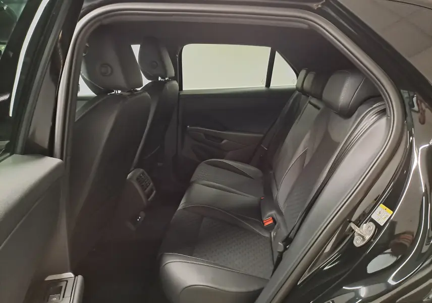 Vue intérieure côté droit des sièges arrière en cuir noir du Volkswagen T-Roc 2026 Noir Ébène, avec détails couture visibles.