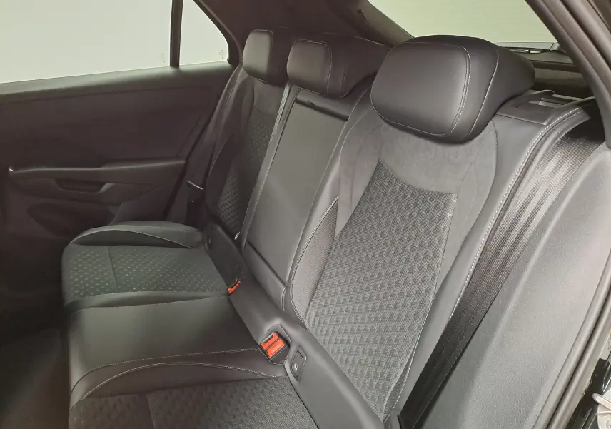 Vue intérieure côté droit des sièges arrière en cuir noir avec surpiqûres blanches du Volkswagen T-Roc 2026.