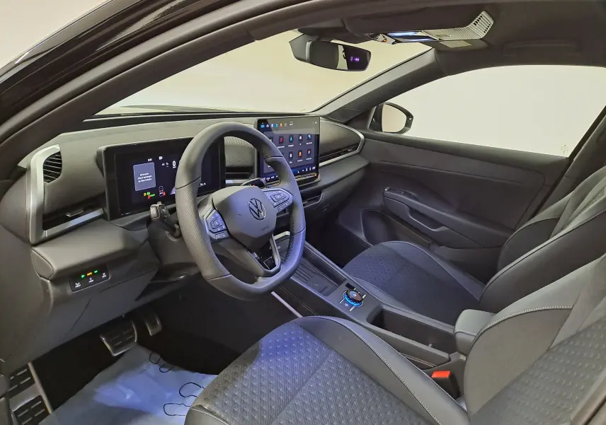 Vue intérieure côté conducteur du Volkswagen T-Roc 2026, tableau de bord numérique et écran tactile central modernes.