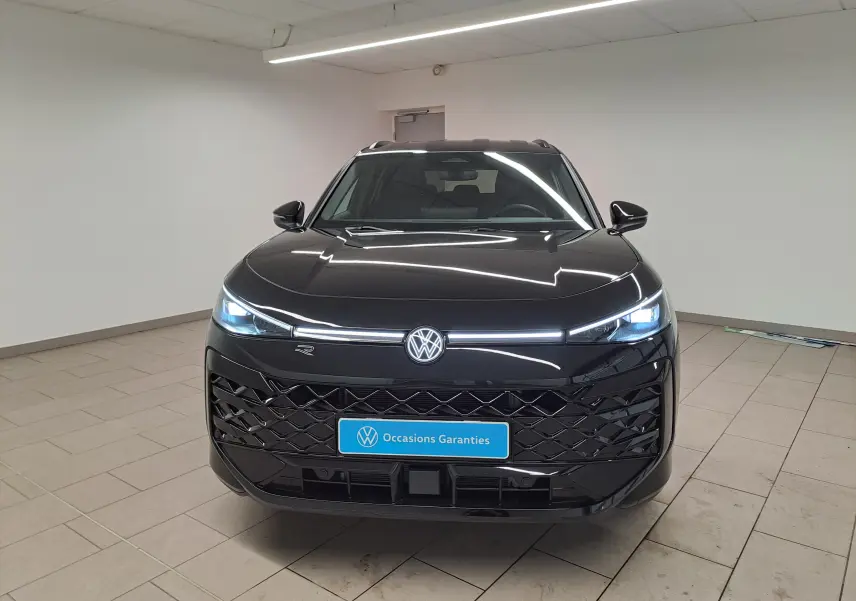 Vue frontale du Volkswagen T-Roc 2026 noir ébène avec phares matrix LED allumés et calandre R-Line distinctive.