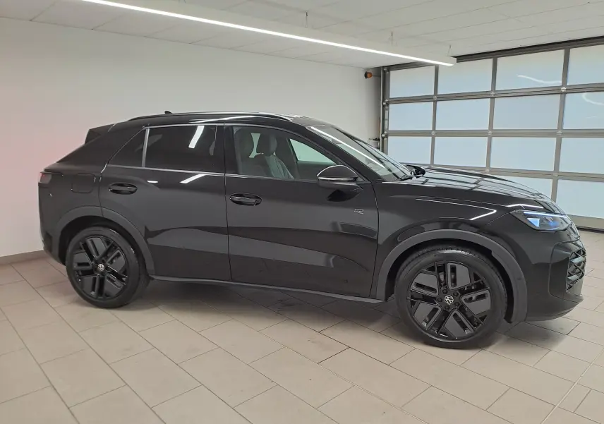 Volkswagen T-Roc 2026 noir ébène en profil droit, avec jantes noires 19 pouces et phares LED matrix allumés.