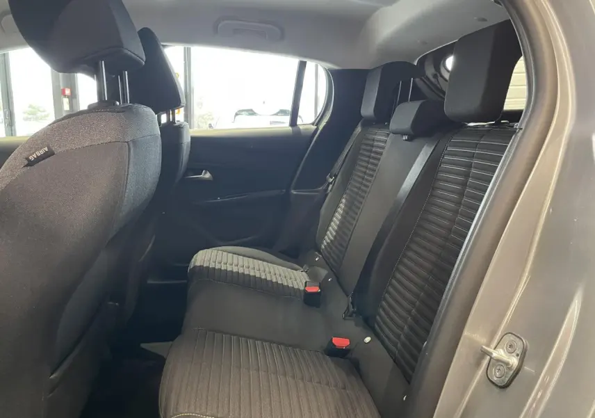 Vue intérieure côté droit sur la banquette arrière noire avec détails de sellerie tissu dans une Peugeot 208 gris clair 2024.