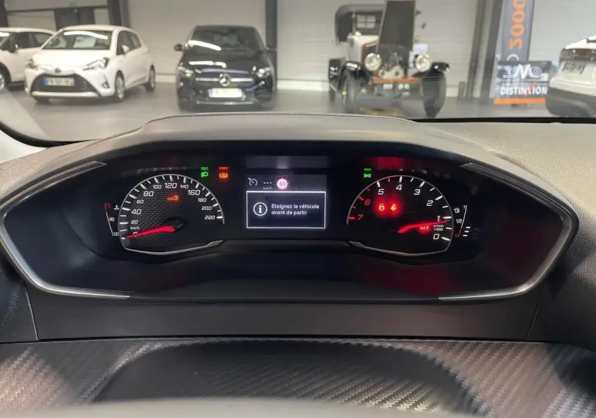 Vue rapprochée du combiné d'instruments Peugeot 208 2024 avec affichage numérique et compte-tours rouge.