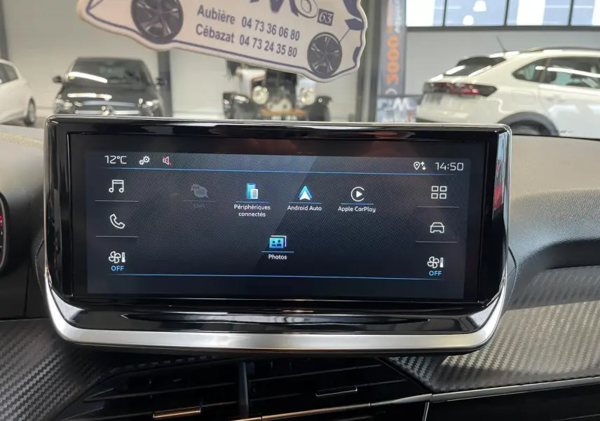 Écran tactile central du tableau de bord de la Peugeot 208 gris clair, avec interface multimédia affichée.