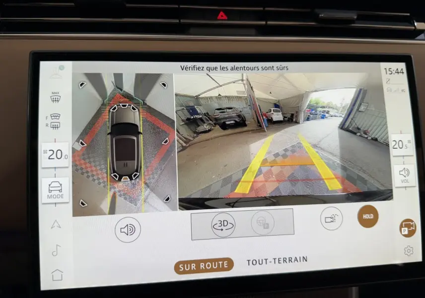 Écran tactile intérieur montrant la caméra 360° et vue arrière du Range Rover PHEV noir en stationnement.