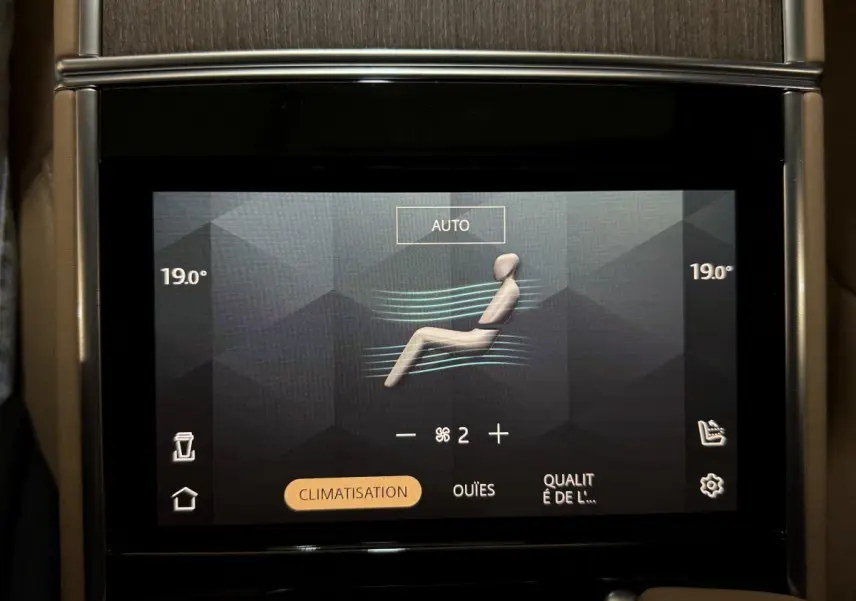 Écran tactile central affichant la climatisation à 19°C dans un Range Rover PHEV noir, vue intérieure rapprochée.