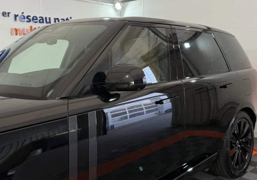 Vue latérale droite d’un Range Rover PHEV P550e Autobiography noir brillant avec rétroviseurs rabattables électriquement.