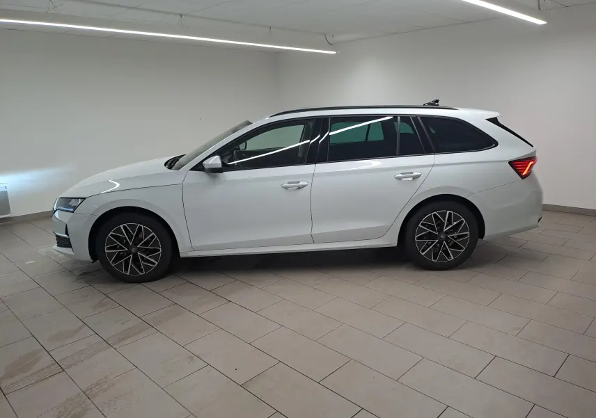 Vue de profil côté gauche d'une Skoda Octavia Combi blanche Moon avec jantes alliage 17'' Slagard Aero noir polies.