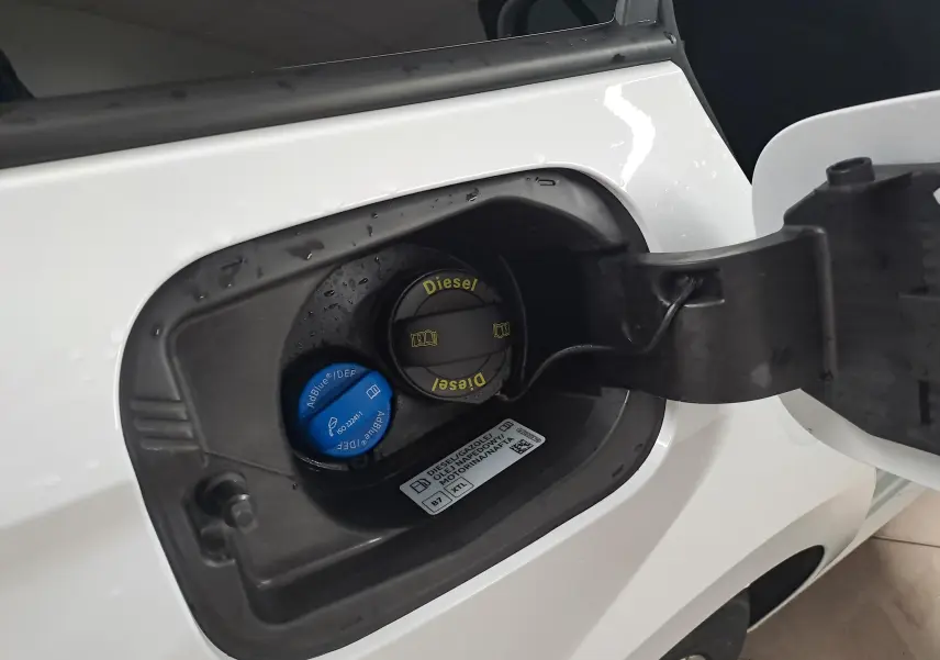 Gros plan sur la trappe à carburant ouverte d’une Skoda Octavia Combi blanc Moon, avec bouchons Diesel et AdBlue visibles.