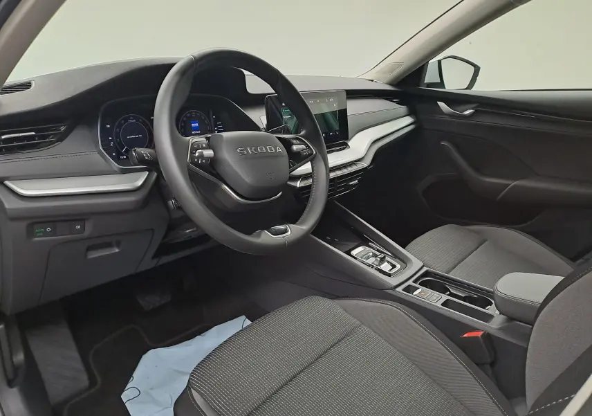Vue intérieure côté conducteur de la Skoda Octavia Combi 2025 avec tableau de bord noir et volant multifonction.