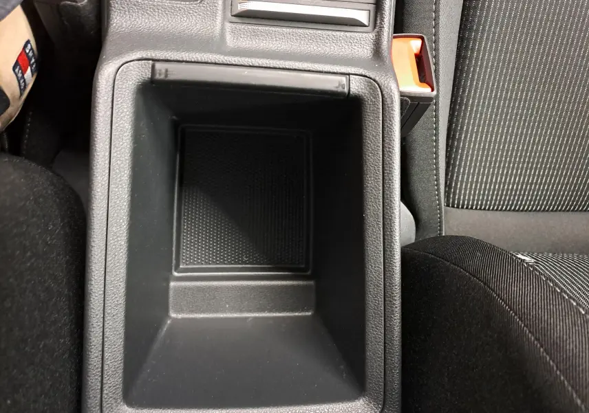 Vue plongeante sur le rangement central noir entre les sièges avant du Skoda Octavia Combi blanc Moon 2025.