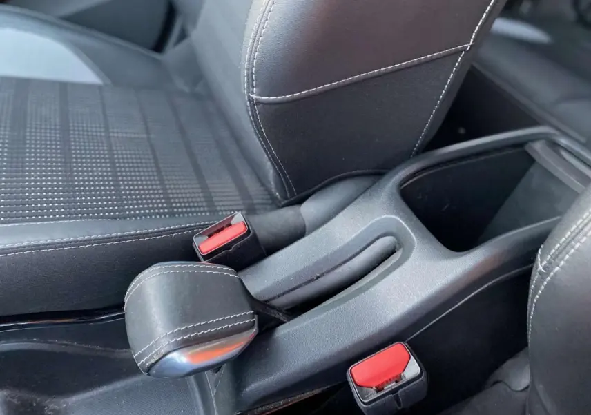 Gros plan sur le frein à main type aviation et les sièges sport noirs avec surpiqûres blanches du Peugeot 2008 2017.