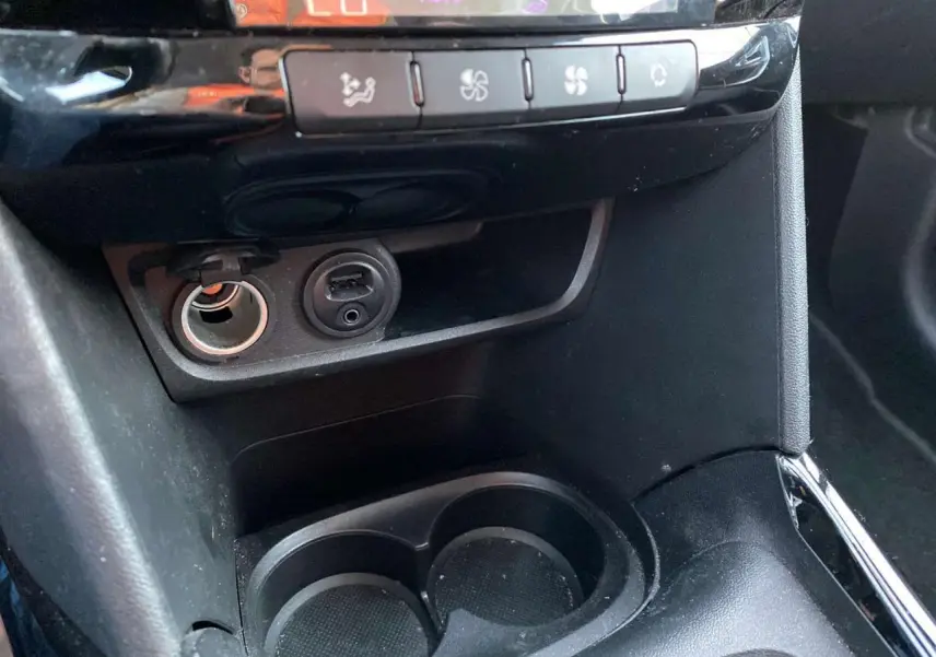 Détail de la console centrale du Peugeot 2008 noir Perla Nera 2017, avec prise 12V, port USB et commandes de climatisation.