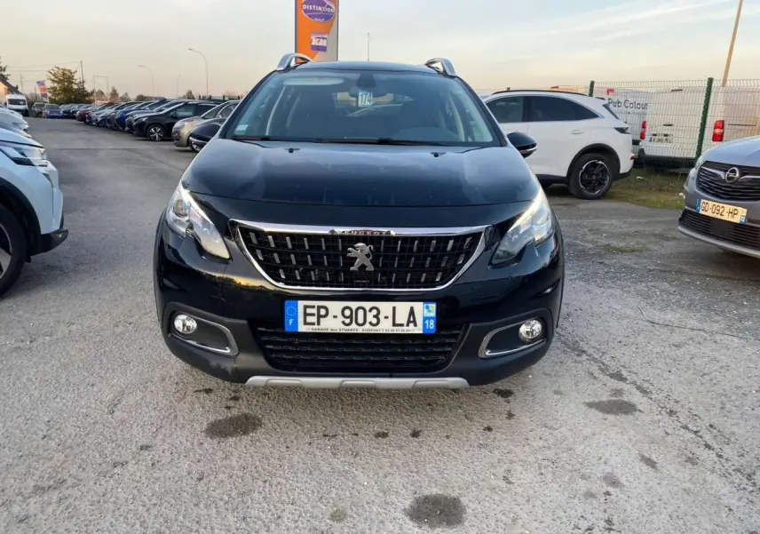 Vue frontale d'un Peugeot 2008 noir Perla Nera avec calandre chromée et feux diurnes LED allumés.