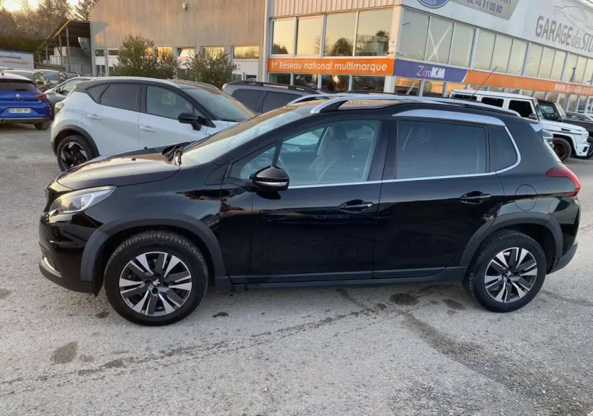 Profil côté gauche du Peugeot 2008 noir Perla Nera 2017 avec jantes aluminium diamantées et bas de caisse noir mat.