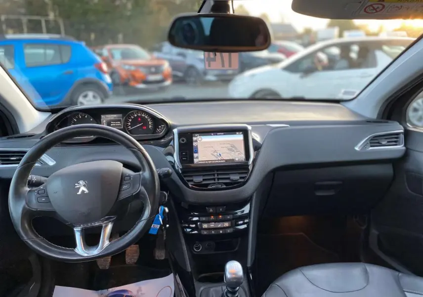 Intérieur de Peugeot 2008 noir Perla Nera 2017, vue frontale sur tableau de bord avec écran tactile et levier manuel.