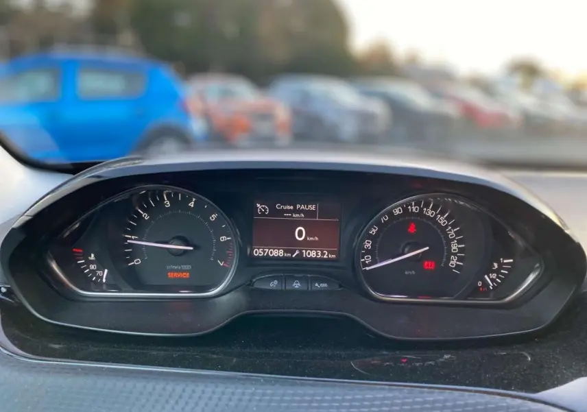 Vue rapprochée du tableau de bord du Peugeot 2008 noir Perla Nera, affichant 57 088 km et régulateur en pause.