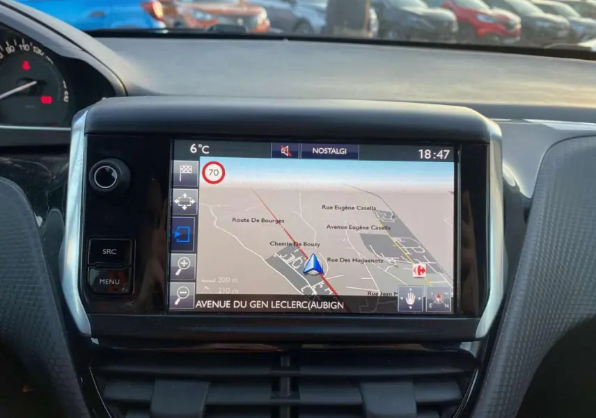 Écran tactile central du tableau de bord d'une Peugeot 2008 noire, affichant la navigation GPS en extérieur.