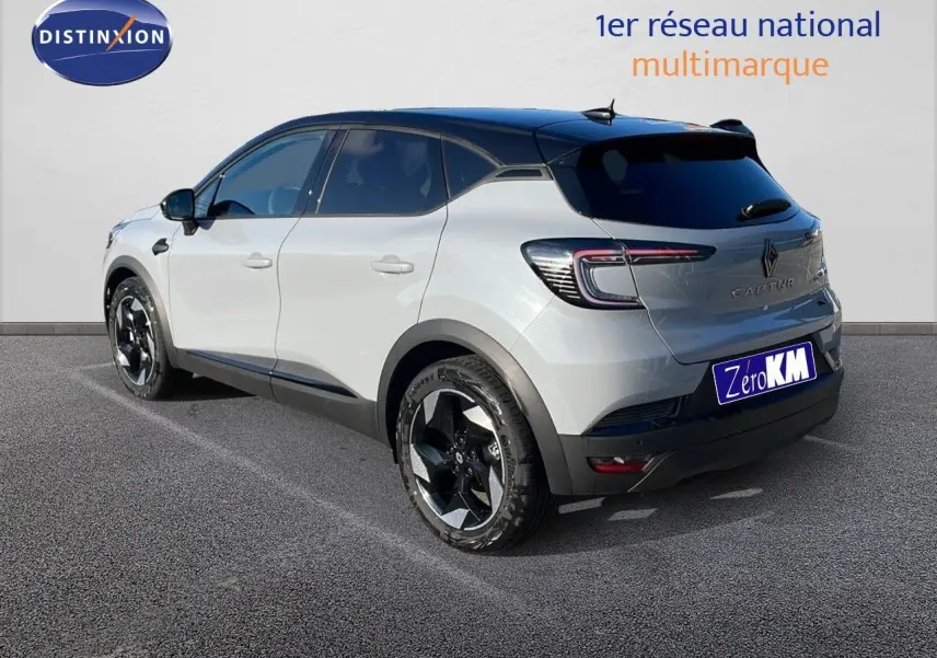 Vue 3/4 arrière droit du Renault Captur gris Rafale métal avec toit noir et jantes biton sur parking.