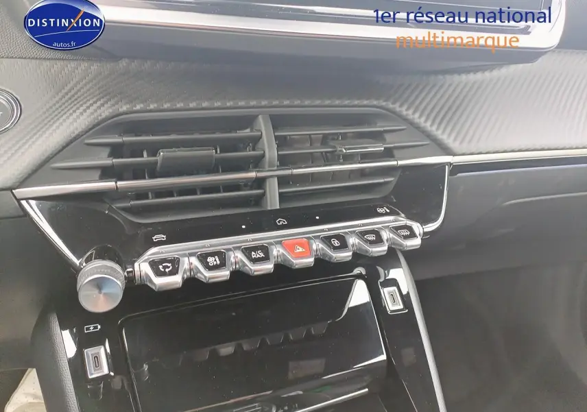 Vue rapprochée du tableau de bord noir brillant du Peugeot 2008 1.2 hybrid 145 GT e-DCS6 avec commandes tactiles et aérateurs.