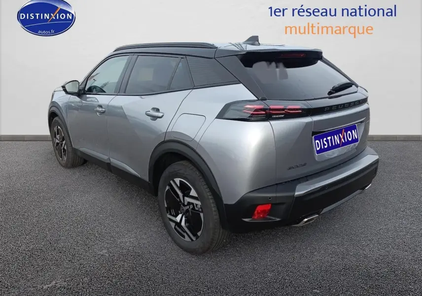 Vue 3/4 arrière droite du Peugeot 2008 hybride 2025 en gris Artense avec toit noir et jantes alu noires.