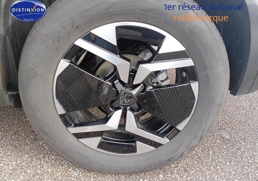 Gros plan sur la jante alu bicolore noire et argentée d'un Peugeot 2008 1.2 hybrid 145 GT e-EAT8 gris Artense.