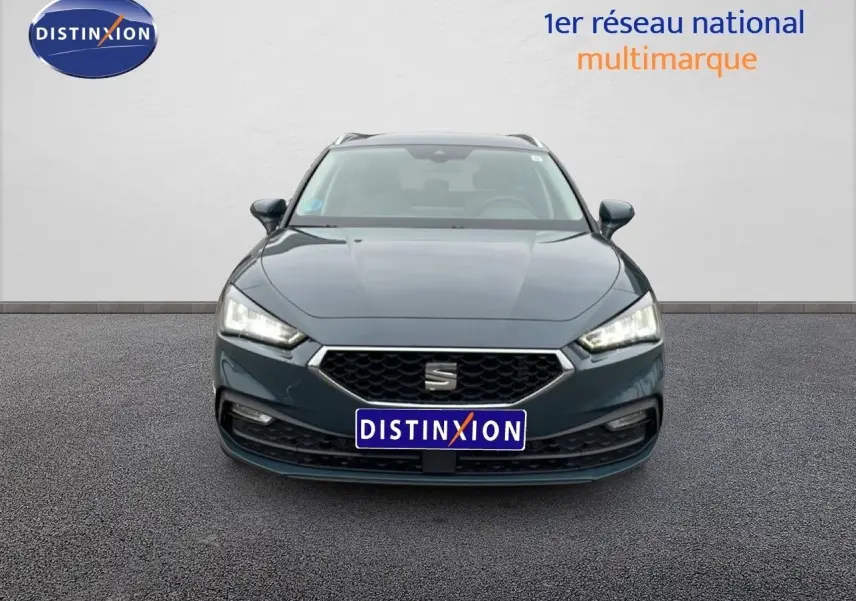 Vue frontale d'une SEAT LEON IV 1.5 TSI gris Fiord avec phares LED allumés sur fond neutre.