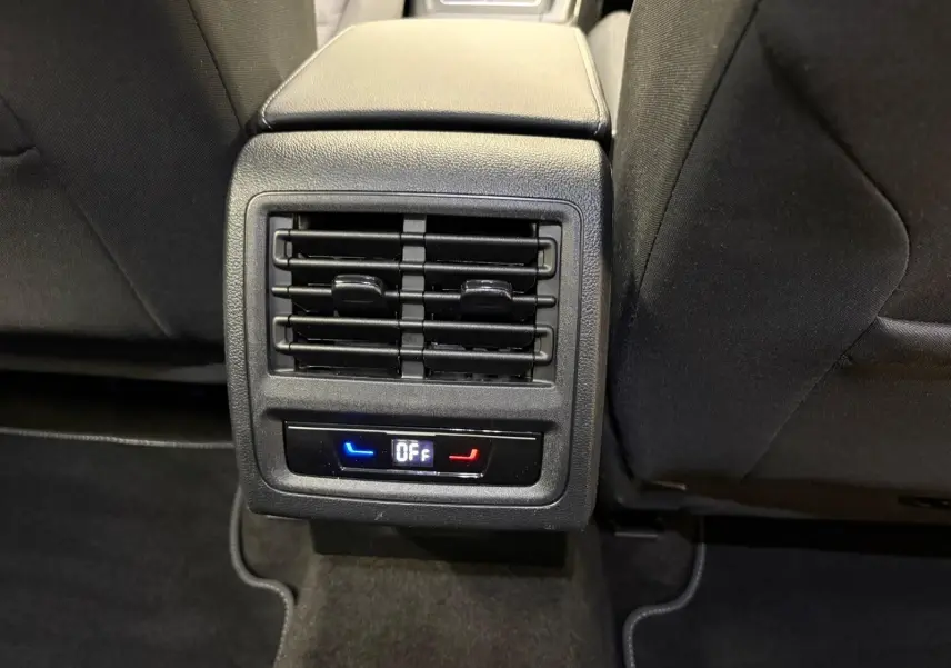 Vue rapprochée de la ventilation arrière et commandes de climatisation sur la console centrale d'une Volkswagen Golf 2025 reflet d'argent.