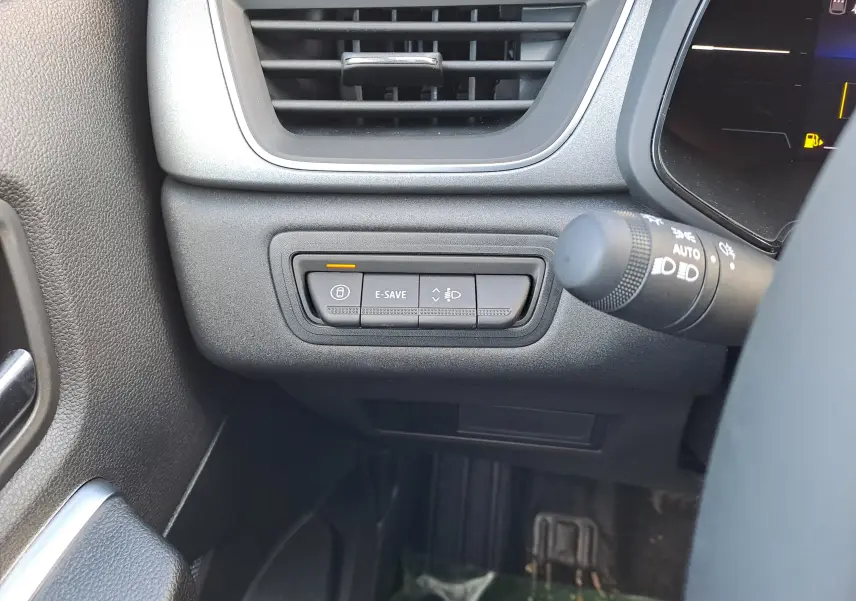 Gros plan sur les commandes E-SAVE et réglage des phares à gauche du volant du Renault Captur blanc nacré 2025.