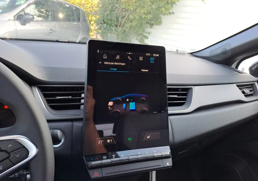 Vue intérieure du tableau de bord du Renault Captur hybride 2025 avec écran tactile central vertical affichant l'énergie du véhicule.