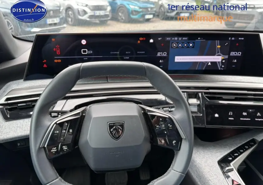Vue intérieure centrée sur le volant cuir multifonction et les écrans numériques du Peugeot 3008 gris titane 2025.