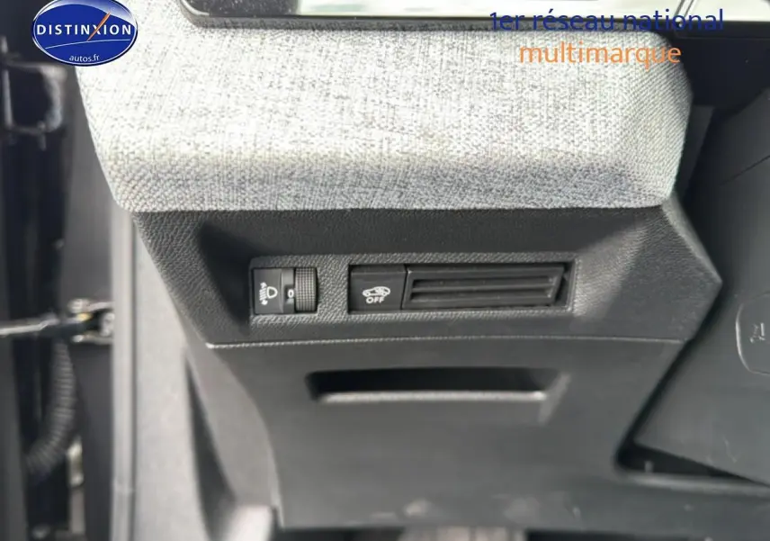 Gros plan sur les commandes sous le tableau de bord côté gauche du Peugeot 3008 gris titane 2025.